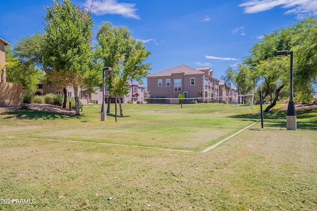 view of home's community with volleyball court and a lawn