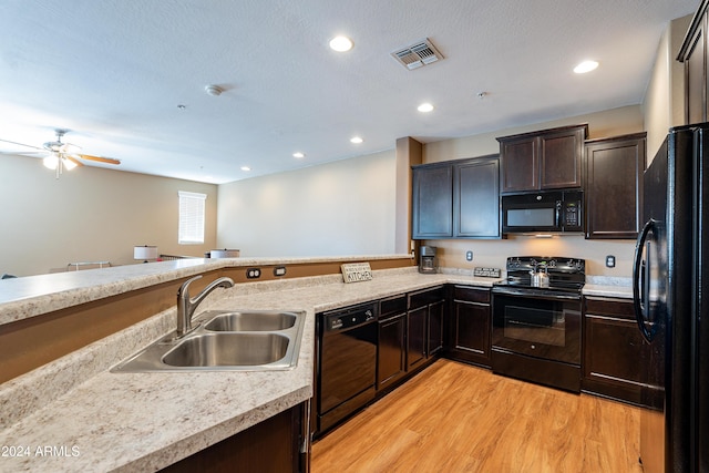 kitchen with ceiling fan, sink, dark brown cabinets, black appliances, and light wood-type flooring