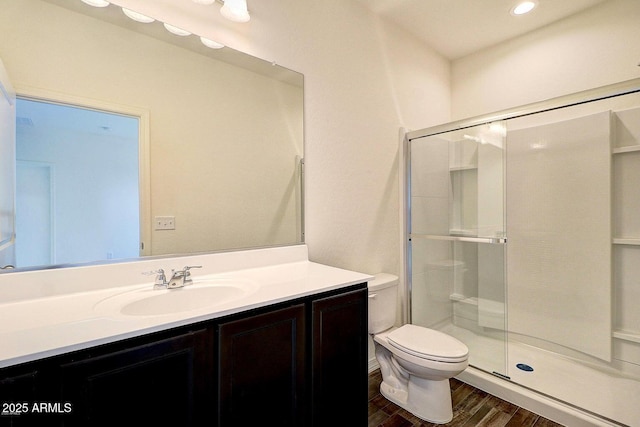 full bath with a shower stall, toilet, vanity, and wood finished floors