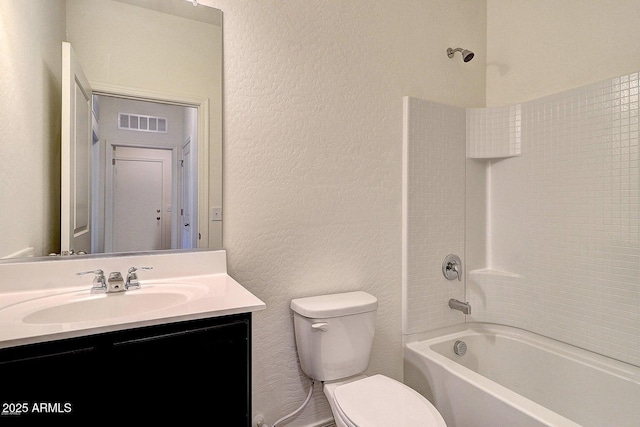 full bathroom with visible vents, shower / washtub combination, toilet, a textured wall, and vanity