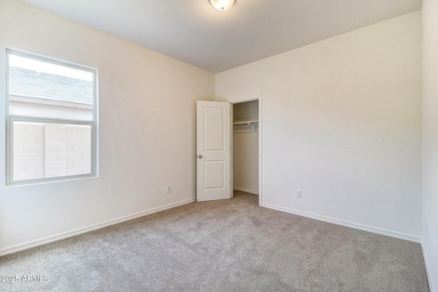 unfurnished bedroom with baseboards, carpet floors, and a closet