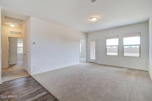 unfurnished room with visible vents, baseboards, and carpet flooring