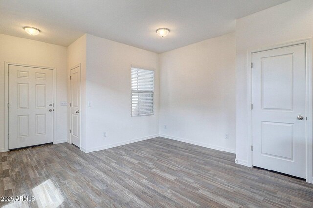 empty room featuring wood finished floors and baseboards