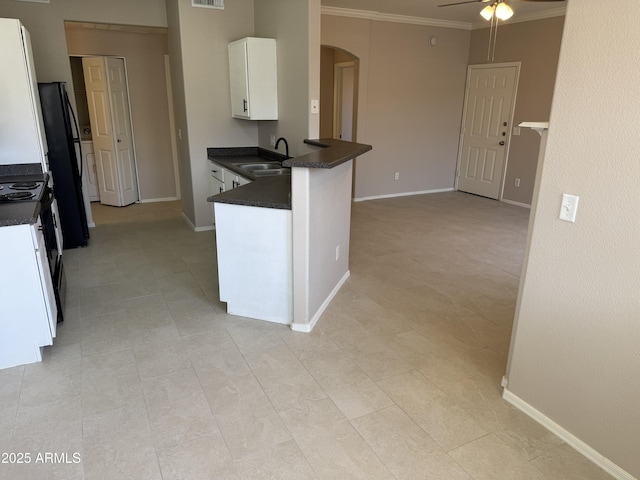1941 S Pierpont Dr Unit 1043, Mesa, AZ 85206 - kitchen with dark countertops, arched walkways, a ceiling fan, white cabinetry, and crown molding