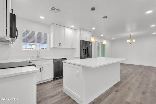 kitchen featuring white cabinetry, appliances with stainless steel finishes, a center island, and sink