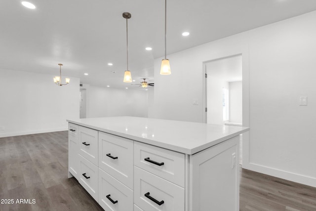 kitchen with white cabinetry, hanging light fixtures, dark wood-type flooring, and ceiling fan