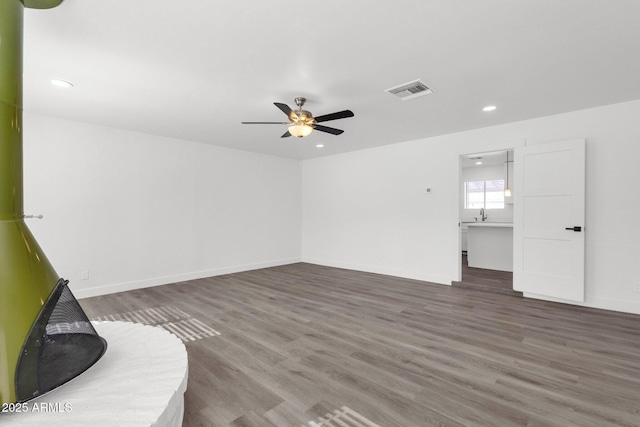 unfurnished living room with dark hardwood / wood-style floors and ceiling fan