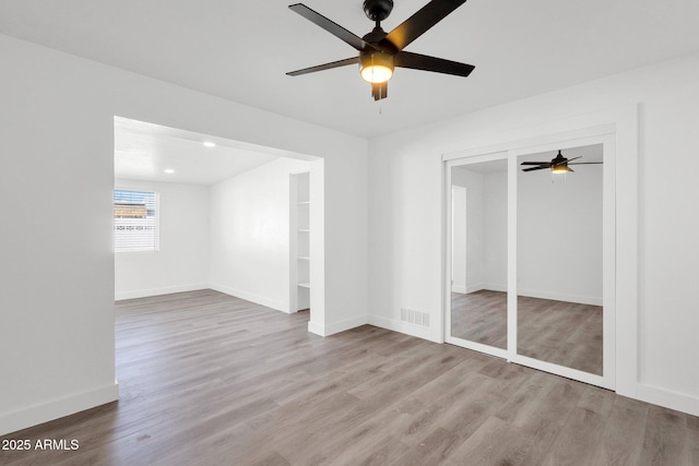 unfurnished bedroom with ceiling fan and light hardwood / wood-style flooring