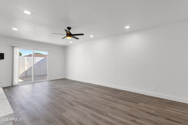 spare room featuring dark wood-type flooring and ceiling fan