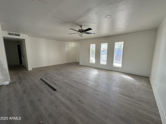 unfurnished room with dark wood-type flooring, ceiling fan, and a textured ceiling