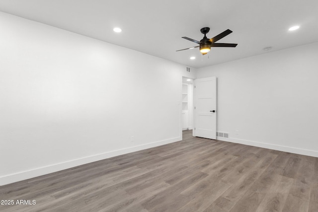 empty room with hardwood / wood-style flooring and ceiling fan