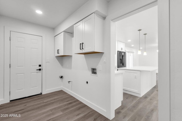 laundry room featuring hookup for a gas dryer, electric dryer hookup, washer hookup, and light wood-type flooring