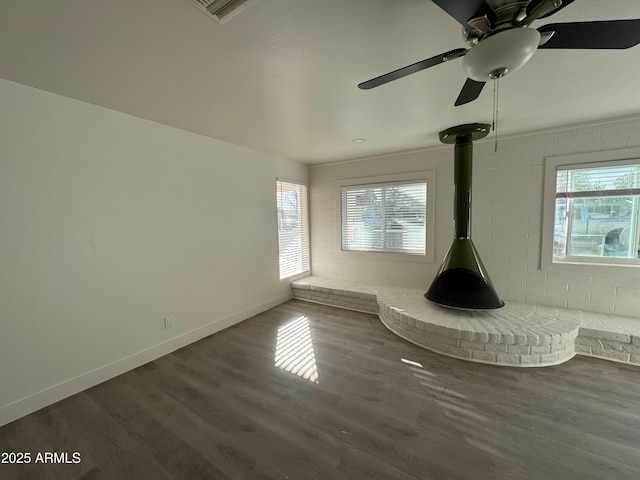 interior space featuring a wood stove and dark hardwood / wood-style flooring