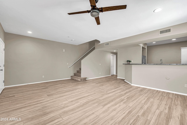 unfurnished living room with ceiling fan and light wood-type flooring