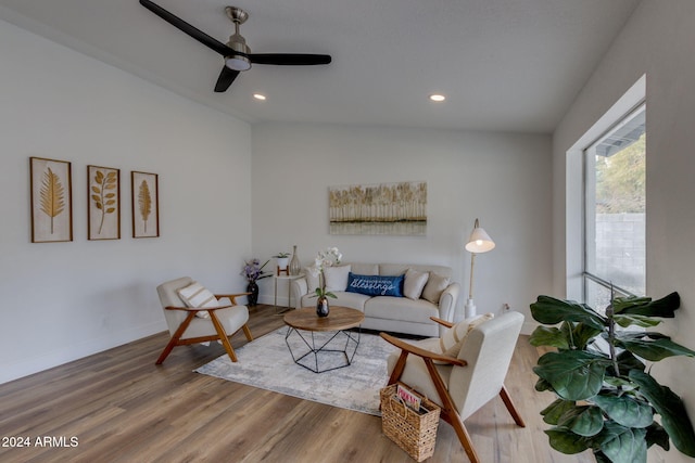 living room with ceiling fan, wood-type flooring, and lofted ceiling