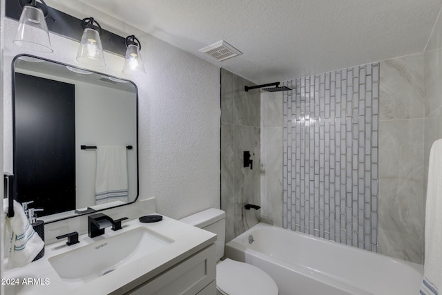 full bathroom with toilet, vanity, a textured ceiling, and tiled shower / bath