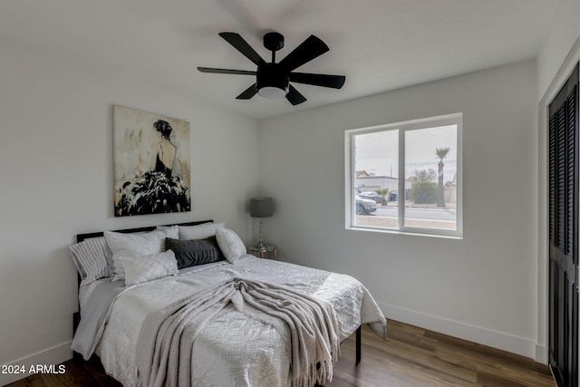 bedroom featuring ceiling fan, a closet, and hardwood / wood-style flooring