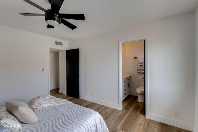 bedroom with ensuite bathroom, ceiling fan, and light wood-type flooring