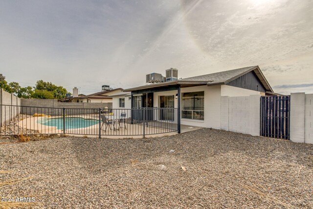 rear view of house with a patio and a fenced in pool