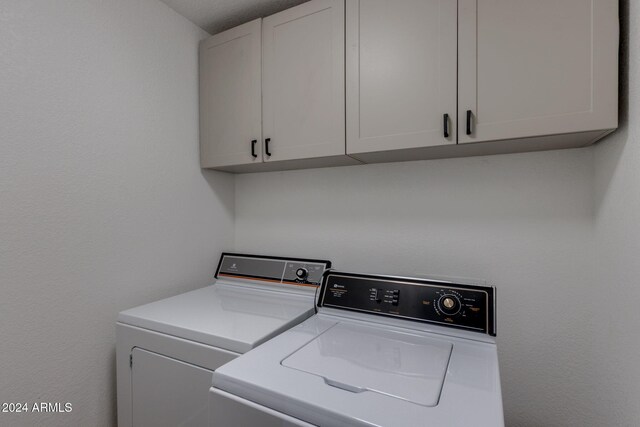 laundry room featuring cabinets and washer and clothes dryer