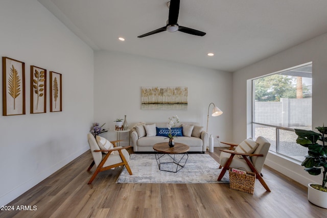 living room with hardwood / wood-style flooring, ceiling fan, and lofted ceiling