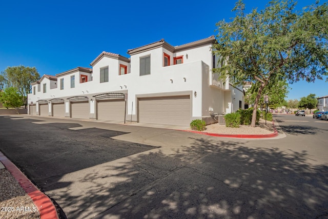3150 E Beardsley Rd Unit 1081, Phoenix, AZ 85050 - view of front facade featuring stucco siding, a garage, and a tile roof