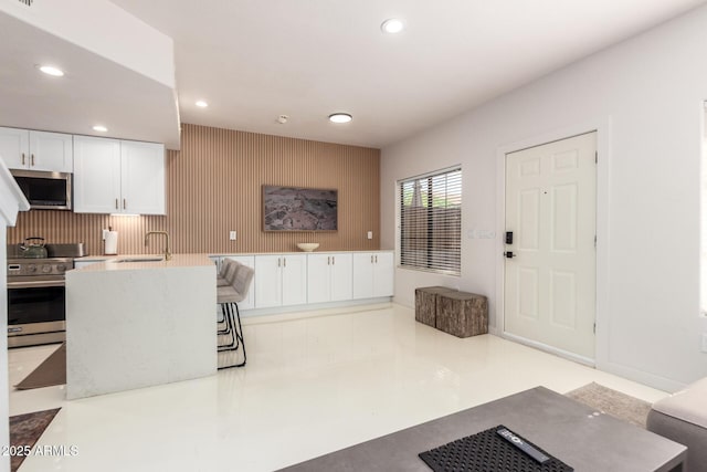 3150 E Beardsley Rd Unit 1081, Phoenix, AZ 85050 - kitchen with appliances with stainless steel finishes, recessed lighting, white cabinetry, light countertops, and an accent wall