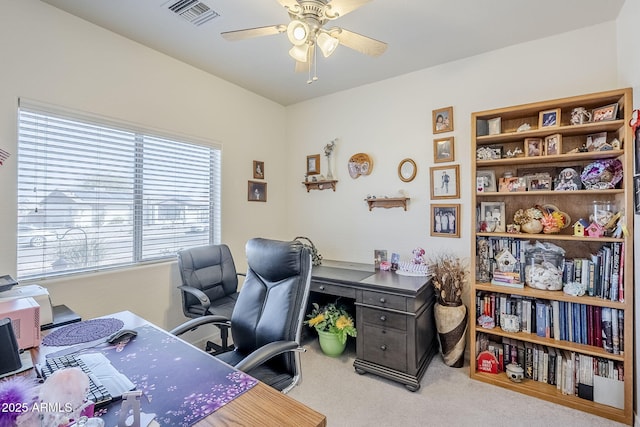 carpeted office space featuring ceiling fan