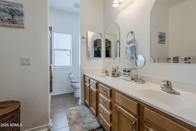 bathroom featuring tile patterned flooring, vanity, and toilet