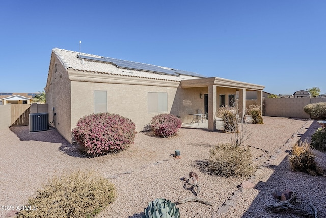 rear view of house featuring central air condition unit, a patio, and solar panels