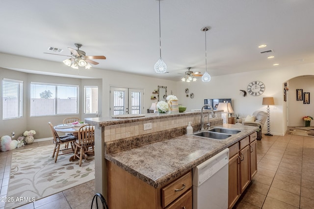 kitchen with a kitchen island with sink, sink, decorative light fixtures, and dishwasher