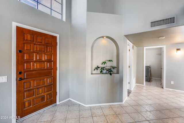 entrance foyer with a towering ceiling and light tile patterned floors