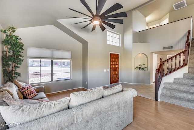 living room featuring light hardwood / wood-style floors, high vaulted ceiling, and ceiling fan