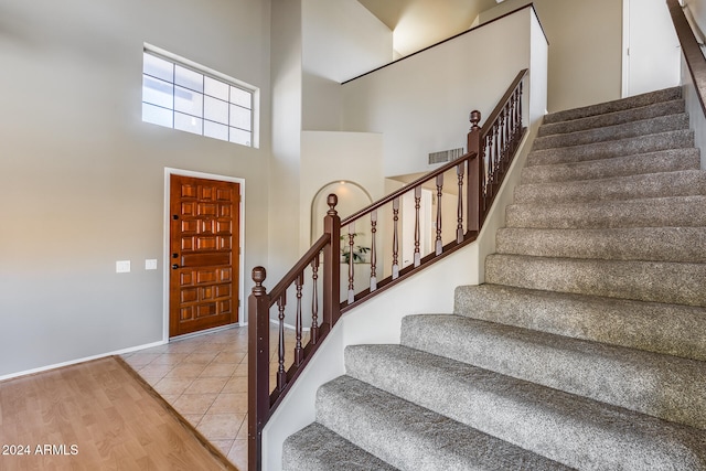 entrance foyer featuring light hardwood / wood-style floors and a towering ceiling