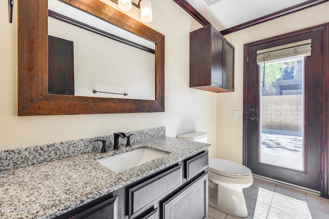 bathroom with toilet, crown molding, vanity, and tile patterned flooring