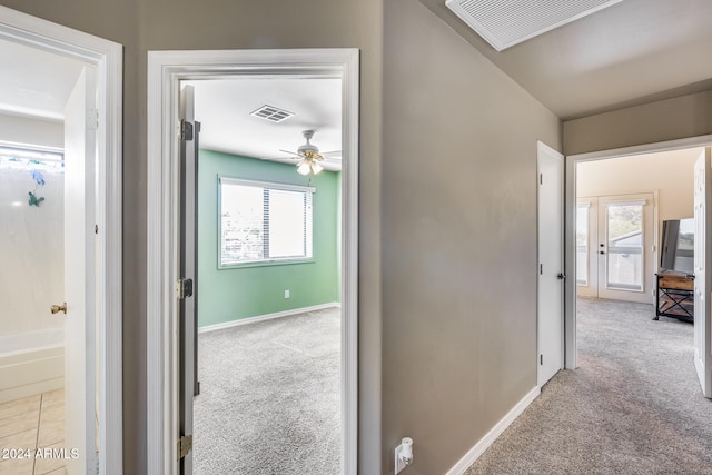 corridor featuring light colored carpet