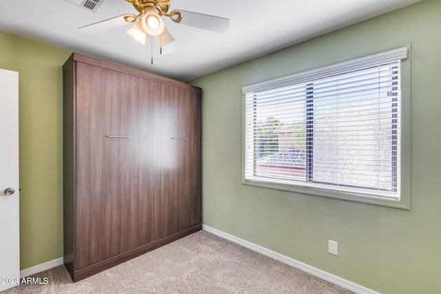 unfurnished bedroom featuring light carpet and ceiling fan