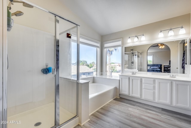 bathroom featuring lofted ceiling, hardwood / wood-style flooring, independent shower and bath, vanity, and ceiling fan