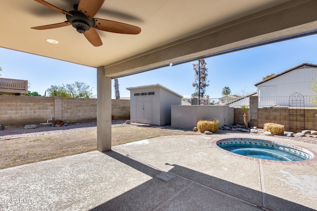 view of patio featuring a storage unit, an in ground hot tub, and ceiling fan