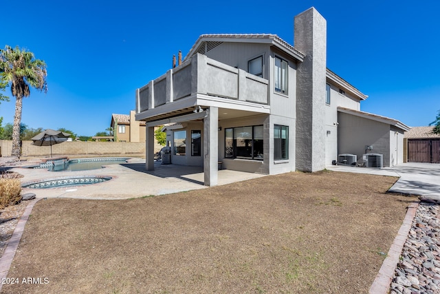 back of property with a fenced in pool, a patio area, cooling unit, and a balcony