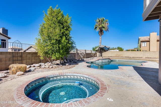 view of swimming pool with an in ground hot tub and a patio