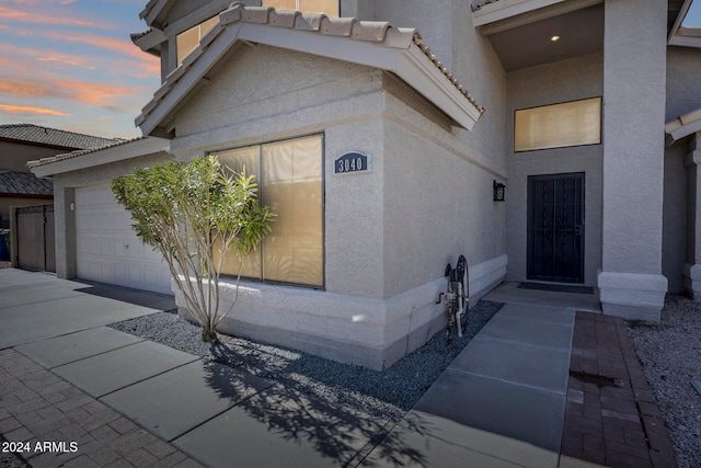 exterior entry at dusk with a garage