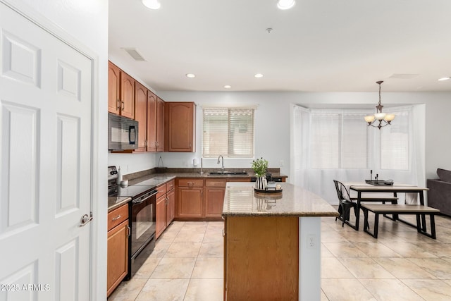 29751 N 119th Ln, Peoria, AZ 85383 - kitchen with black appliances, a kitchen island, dark stone countertops, a sink, and decorative light fixtures