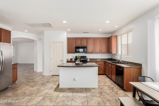 29751 N 119th Ln, Peoria, AZ 85383 - kitchen featuring black appliances, a sink, arched walkways, a kitchen island, and recessed lighting