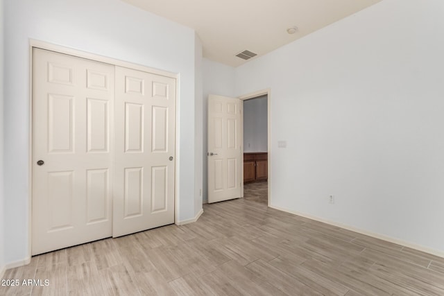 29751 N 119th Ln, Peoria, AZ 85383 - unfurnished bedroom with light wood-type flooring, a closet, and baseboards