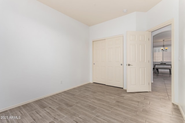 29751 N 119th Ln, Peoria, AZ 85383 - unfurnished bedroom featuring wood finish floors, a chandelier, a closet, and baseboards