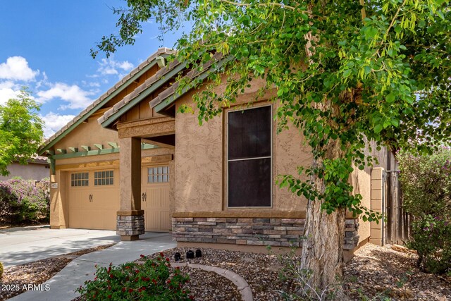 29751 N 119th Ln, Peoria, AZ 85383 - view of front of house with concrete driveway, a garage, stone siding, and stucco siding