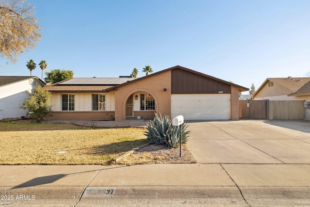 ranch-style home with a garage and solar panels