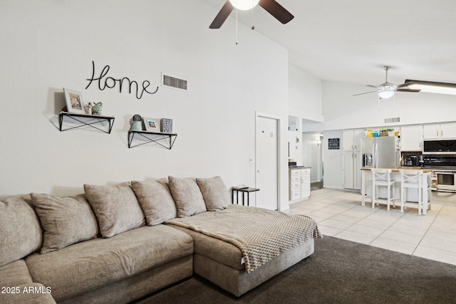 tiled living room featuring ceiling fan and high vaulted ceiling