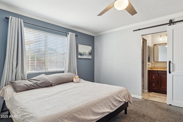 carpeted bedroom with crown molding, ceiling fan, connected bathroom, and a barn door